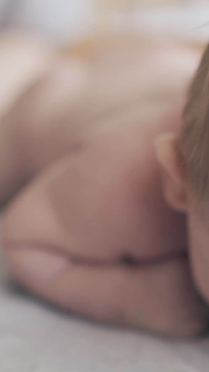 professional pediatrician practices hypertonus leg massage on lying on stomach infant boy close view