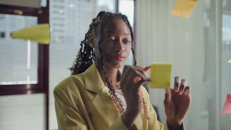 African American Business Woman Write Tasks Creative Ideas On Sticky Notes On Glass Board Female Corporate Leader Planning Project On Post It Sticky Notes Organize Work On Stickers