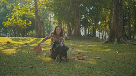 Woman playing with her dog in a park
