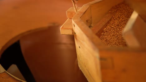 wooden mill grinds grains into fine flour close-up shot inside a traditional millhouse