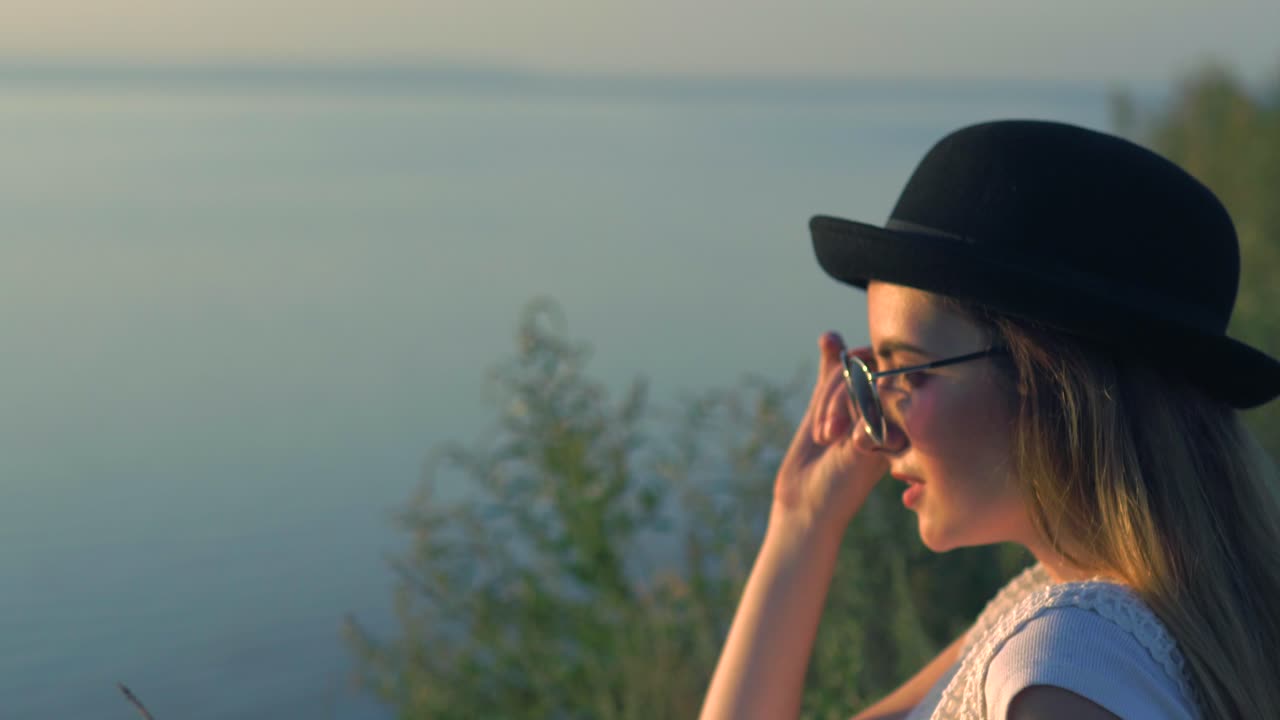 una mujer disfrutando de una tranquila puesta de sol junto al lago.