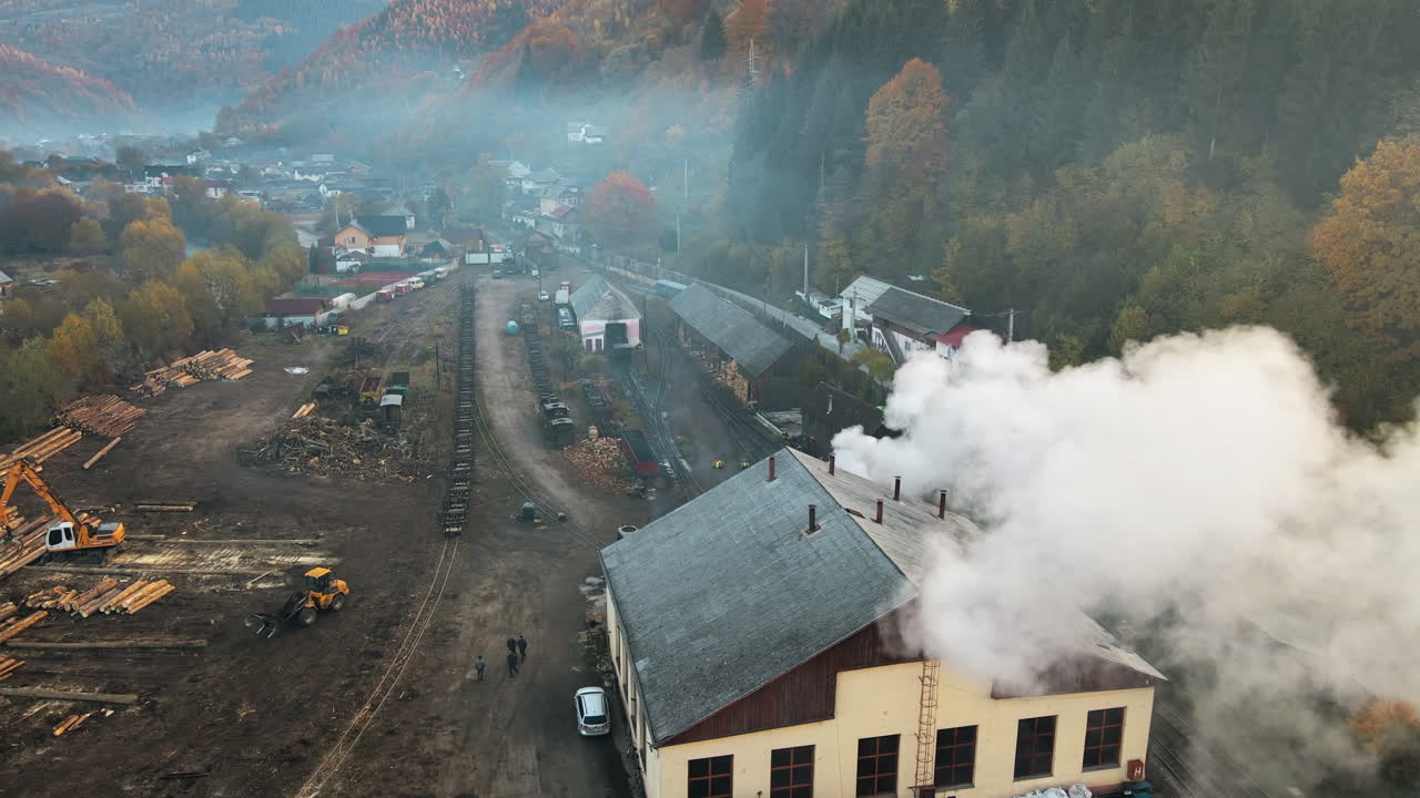 Aerial drone view of the moving steam train Mocanita at the railway station in Viseu de Sus, Romania