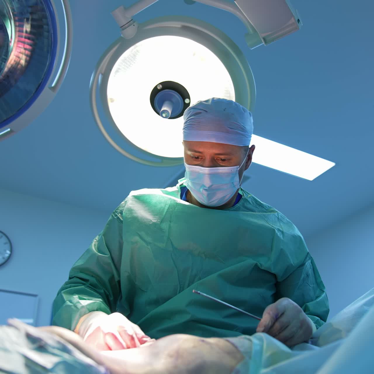 Liposuction. Surgeon in medical uniform performing abdominoplasty. Surgical removal of fat from the abdomen of a patient in the operating room