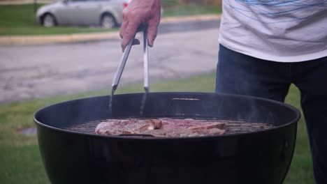 flipping steak on grill - bbq outdoor