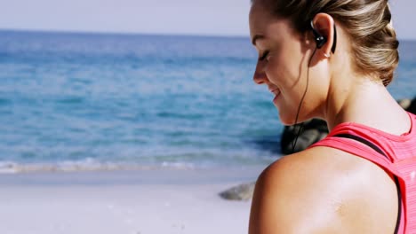 fit woman putting music on mobile phone before jogging