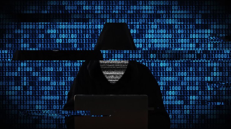 Hacker al computer con sfondo di codice binario.