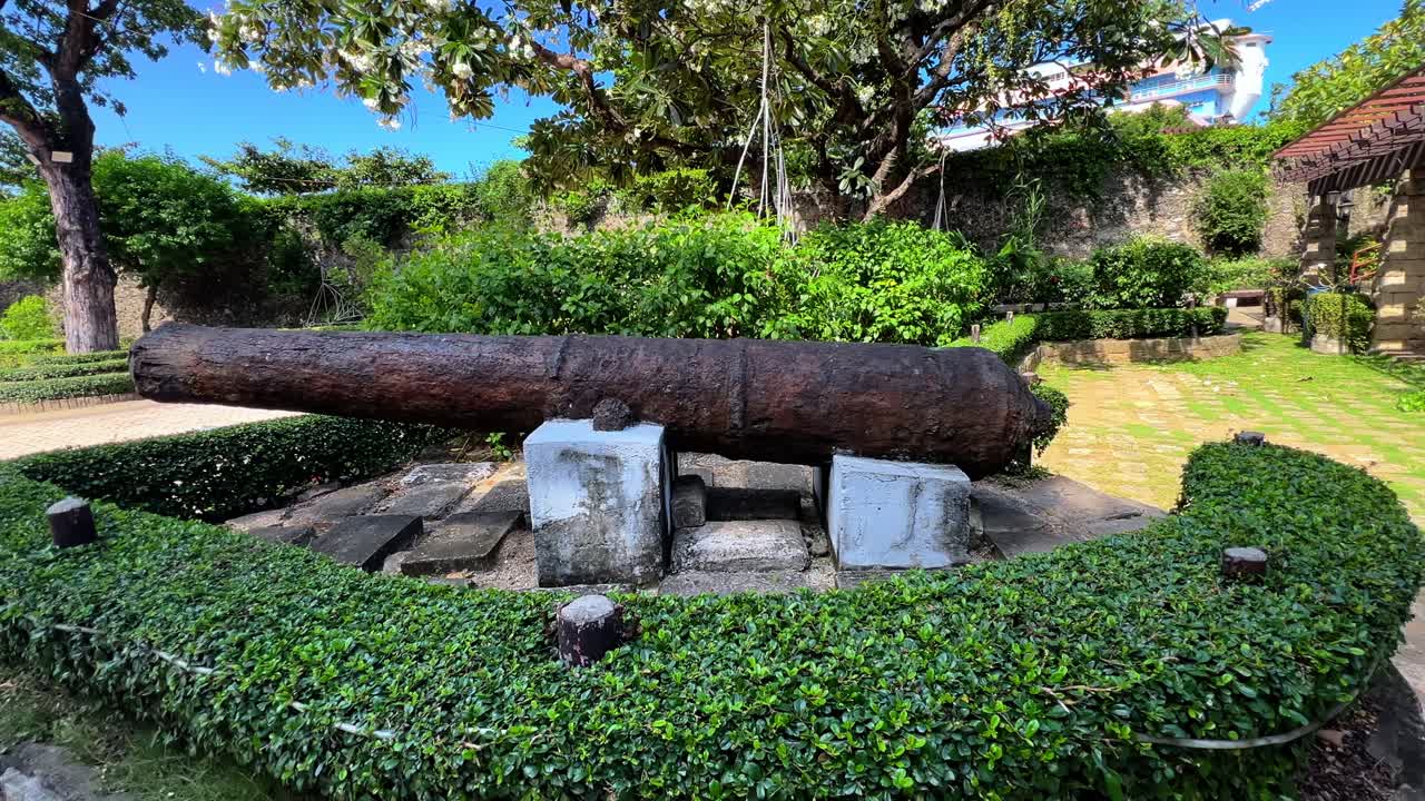 Historic rusted cannon displayed in a sunlit heritage garden—perfect for themes of war history, tourism, or cultural preservation