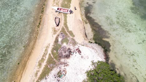 Vista-Aérea-De-Aves-Inclinada-Hacia-Arriba-Pescadores-Caminan-Pueblo-Pesquero,-Isla-Fernado-Los-Roques