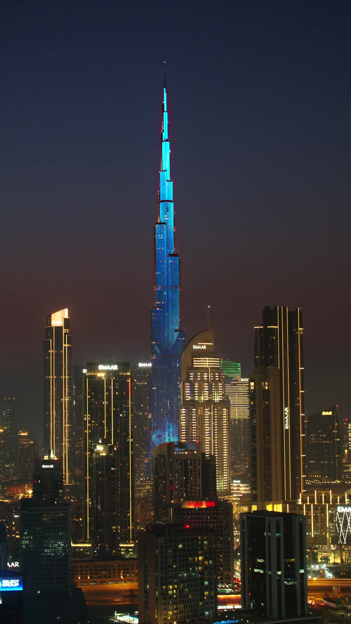 Dubai, EAU - 28 de julho de 2026: Timelapse vertical do dia para a noite do arranha-céu Burj Khalifa e do horizonte circundante do centro de Dubai, apresentando as torres iluminadas da incorporadora Emaar
