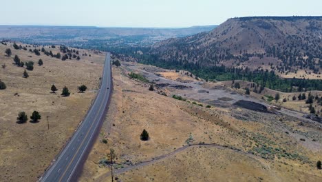 drone aerial landscape of road highway freeway with rolling hills mountains cliffs desert countryside warm springs indian reservation oregon usa america nature outdoors travel