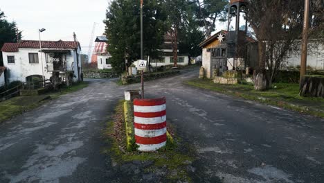 Push-in-to-entrance-of-Benposta-in-Ourense-with-split-in-the-wet-dark-asphalt-road