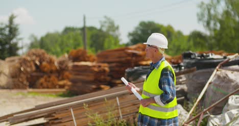 Male-Worker-Examining-Plank'S-Stack