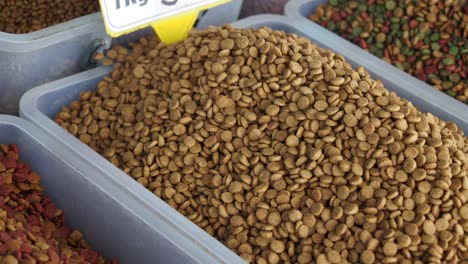 close-up view of brown pet food kibble in a bin at a pet store