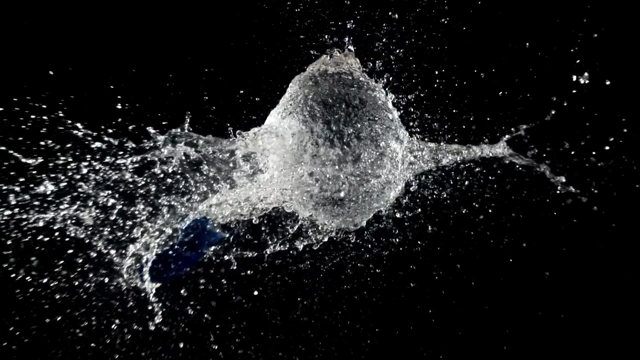 Palloncino d'acqua blu che scoppia al rallentatore su sfondo nero