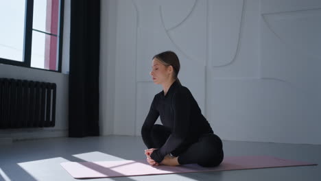 mujer haciendo estiramientos de yoga en un estudio