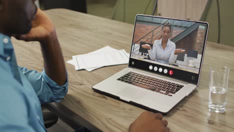 African-american-man-using-laptop-for-video-call,-with-business-colleague-on-screen