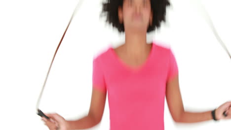 mujer atlética sonriente haciendo salto de cuerda