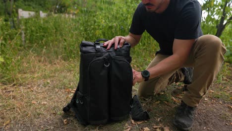 El-Fotógrafo-Masculino-Se-Mete-En-La-Bolsa-De-La-Cámara-Saca-El-Equipo-De-Fotografía-De-Drones-Al-Aire-Libre-En-Un-Entorno-Forestal