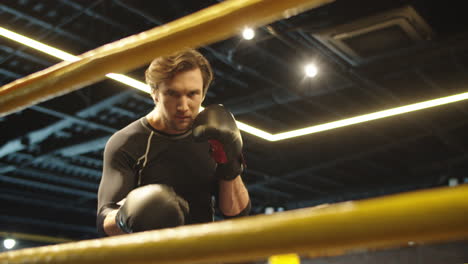 male boxer doing punches on boxing ring