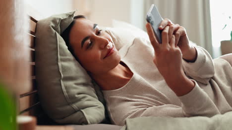 woman using smartphone in bed