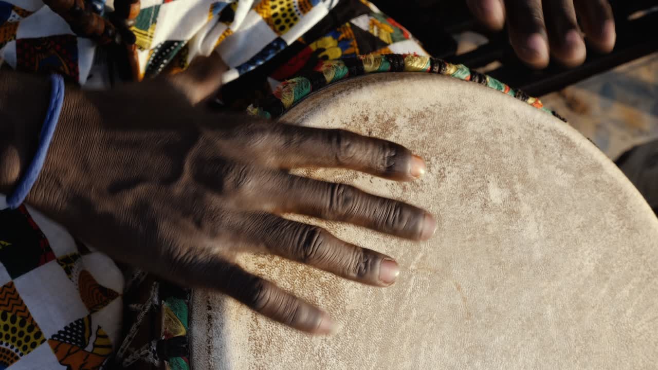 un senegalés toca un tambor tradicional de djembe.