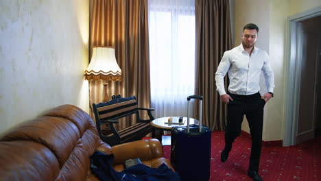 handsome man in a hotel room. young businessman arrived into the hotel and sitting on a sofa after a tiring journey.