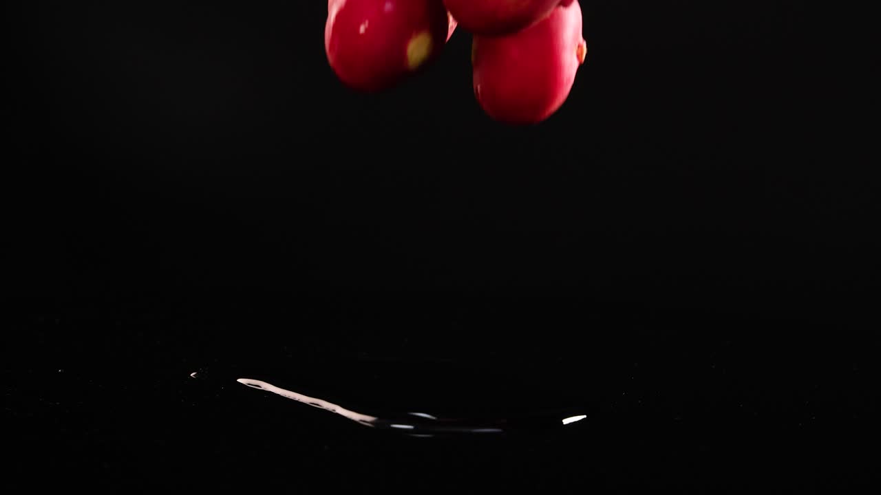 Radishes fall and bounce on a glossy black surface, captured in slow motion with dramatic lighting