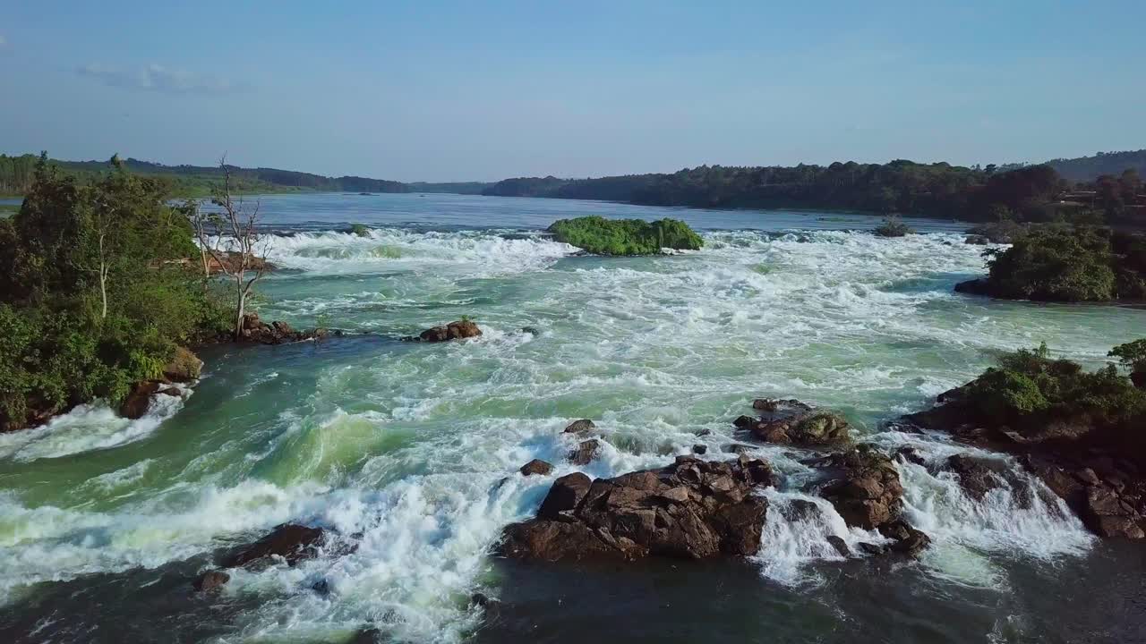 Whitewater rapids flowing on the River Nile in Uganda, Africa, showcasing the powerful currents and lush vegetation surrounding the riverbanks, creating a dynamic scene of natural beauty and force