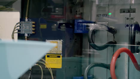 close-up of industrial machinery with hoses and warning sign
