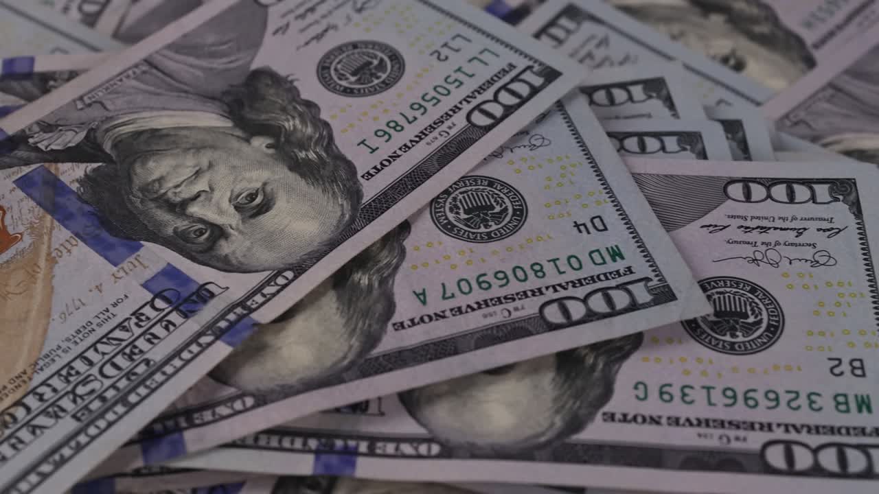 Denaro contante statunitense sparso sulla scrivania con banconote in dollari americani.