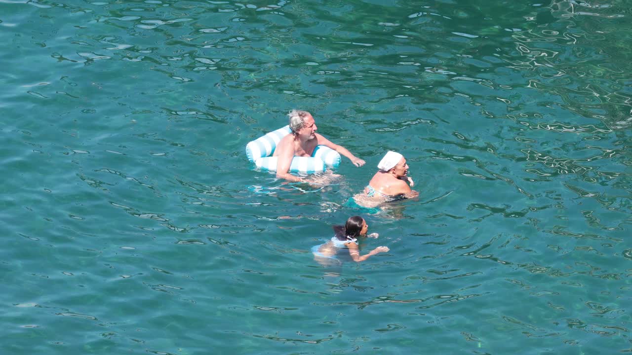 Family enjoying a swim and sharing a kiss
