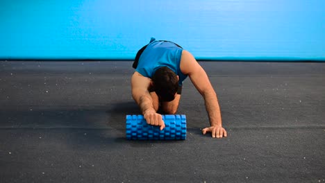 a-hand-held-shot-of-a-guy-using-a-massage-roller-with-only-his-bodyweight