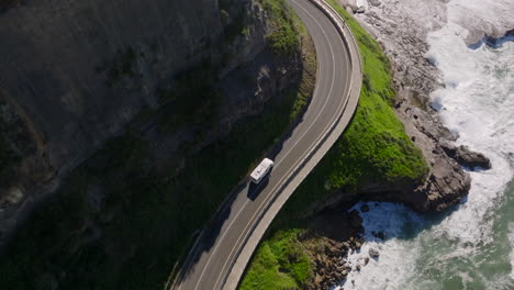 campervan cruising over famous sea cliff bridge in victoria, australia