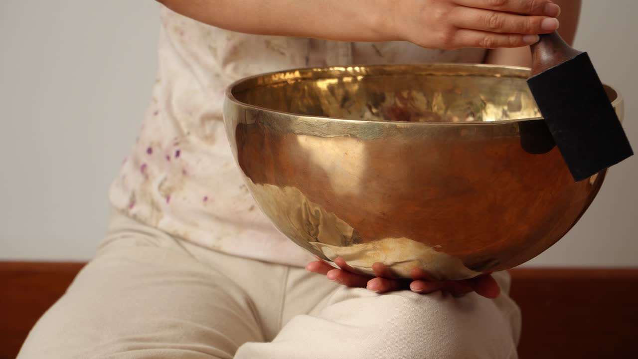 Woman producing singing bowl vibrations and tones