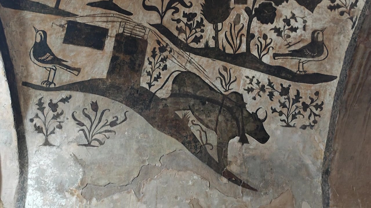 Antico murale raffigurante buoi e uccelli su parete di pietra