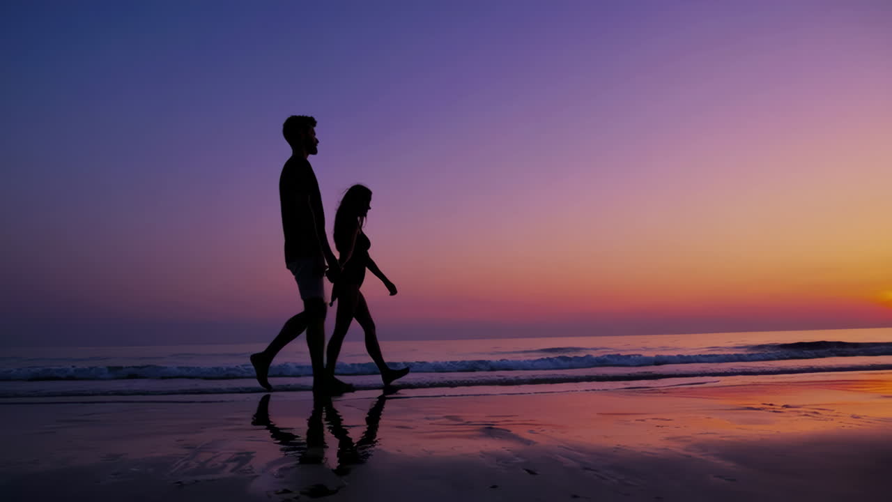 해가 지는 동안 해변을 고 있는 부부