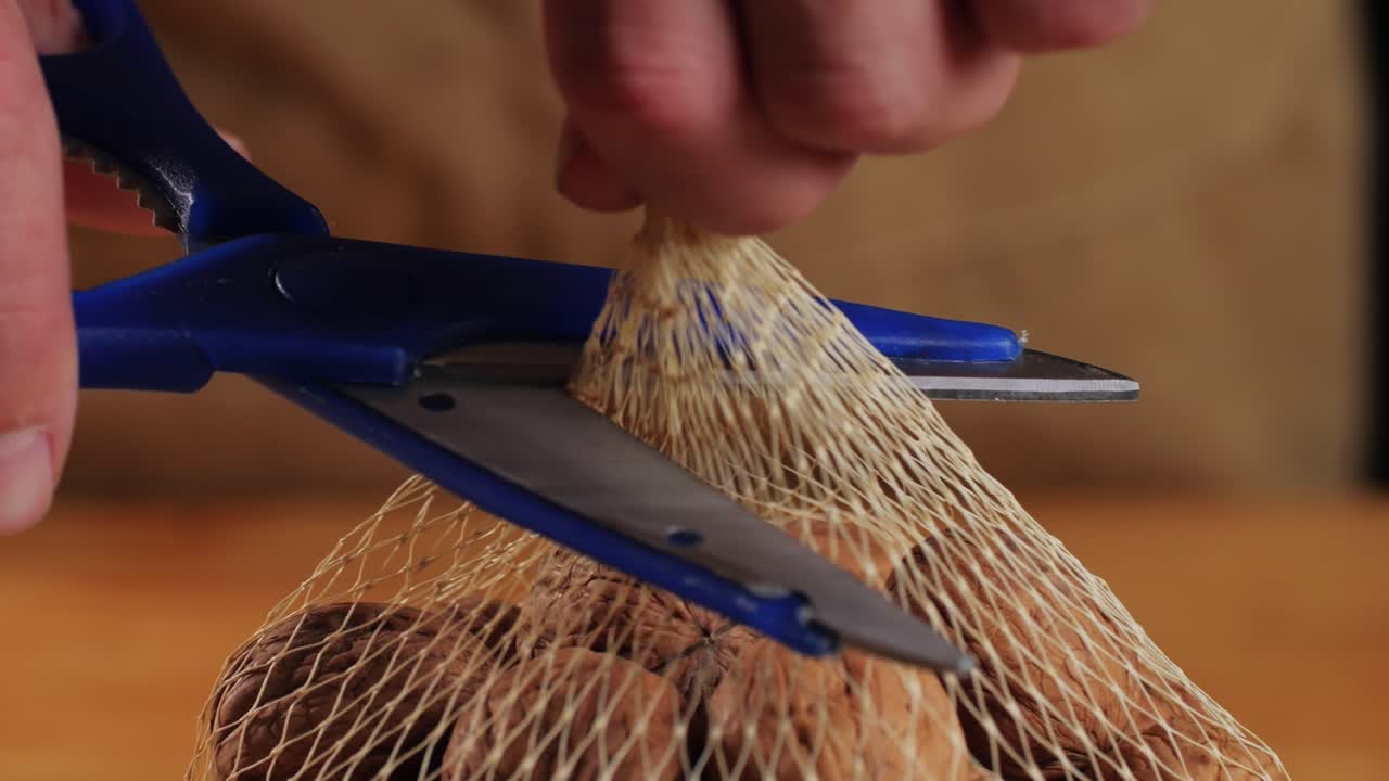 Opening a Mesh Bag of Walnuts with Scissors