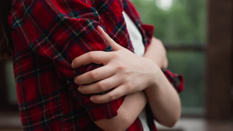 lady finds solace in selfembrace at home woman in red shirt seeks warmth tightly crossing arms in