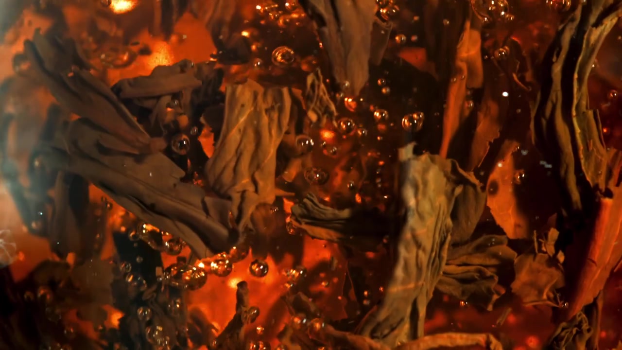 Gros plan de feuilles de thé infusant dans de l'eau chaude avec des bulles