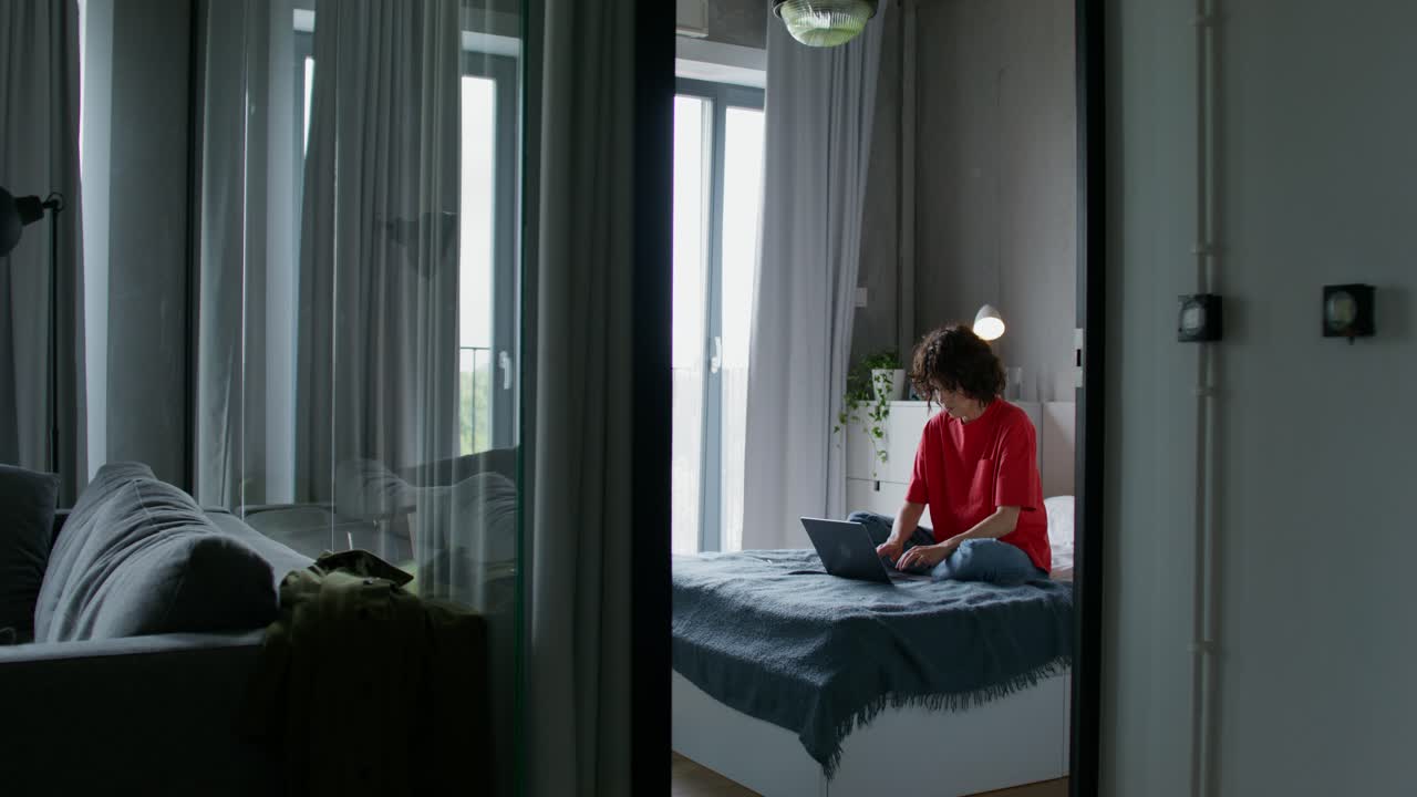 женщина работает на ноутбуке в своей уютной спальне