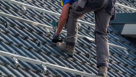 Worker-Attaches-Wire-Box-to-Solar-Panel-Railing-Mounts-on-Roof