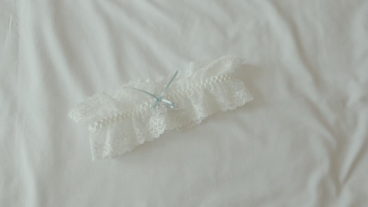 Liga de novia de encaje con cinta azul sobre superficie de tela