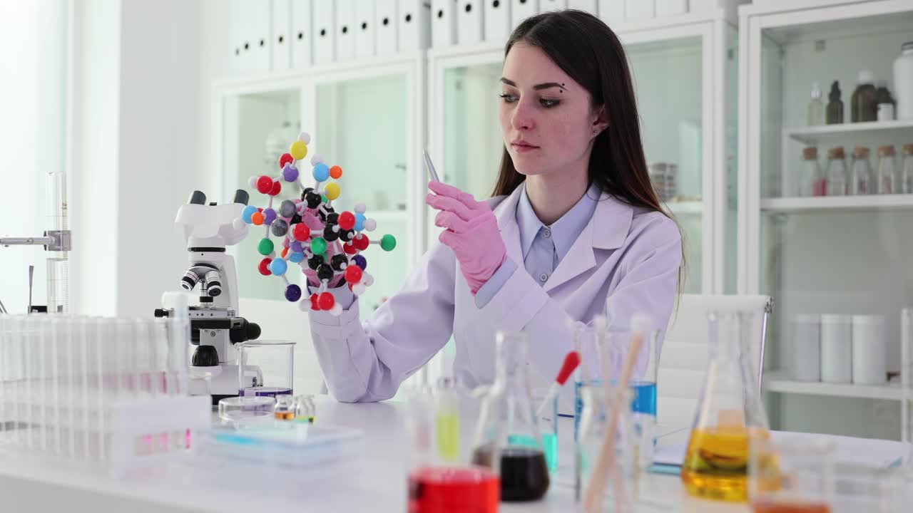 Scientist studying a molecule model in a lab