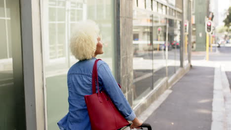 Young-biracial-woman-with-curly-blonde-hair-enjoys-the-cityscape