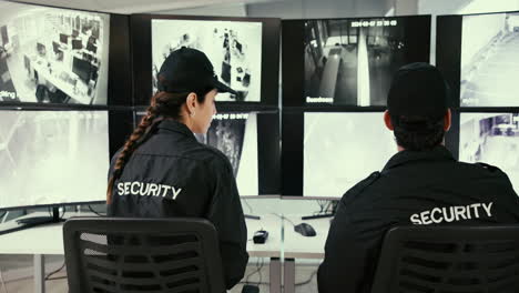 security guards monitoring security cameras in an office