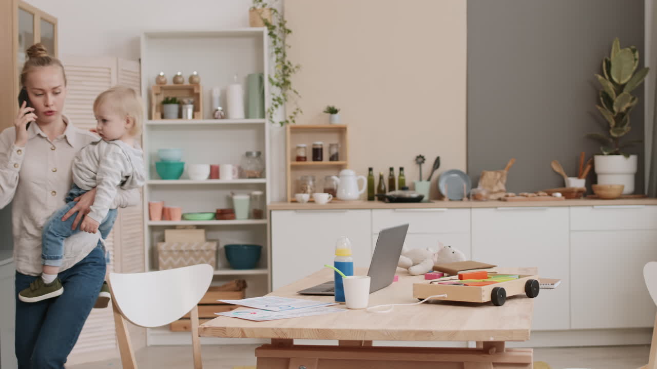 Woman Carrying Toddler and Working Home