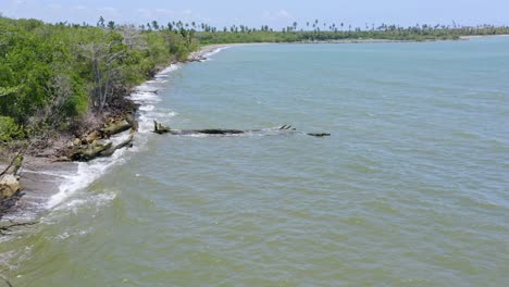 Drone-flying-over-waters-along-mouth-of-Soco-river,-San-Pedro-de-Macoris-in-Dominican-Republic