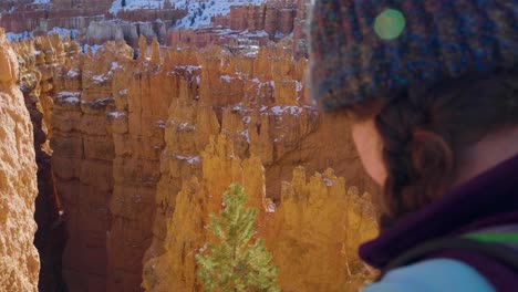 girl woman hiking with red rocks formation and snow near bryce canyon in southern utah