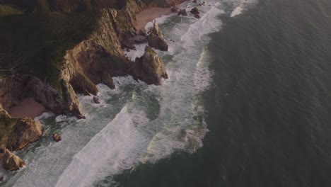 Aerial-view-of-rough-coast-line-high-cliffs-at-Cabo-da-Roca-during-sunset,-drone-shot