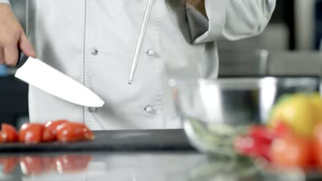 male chef sharpening knife in slow motion. closeup chef hands preparing to cook.